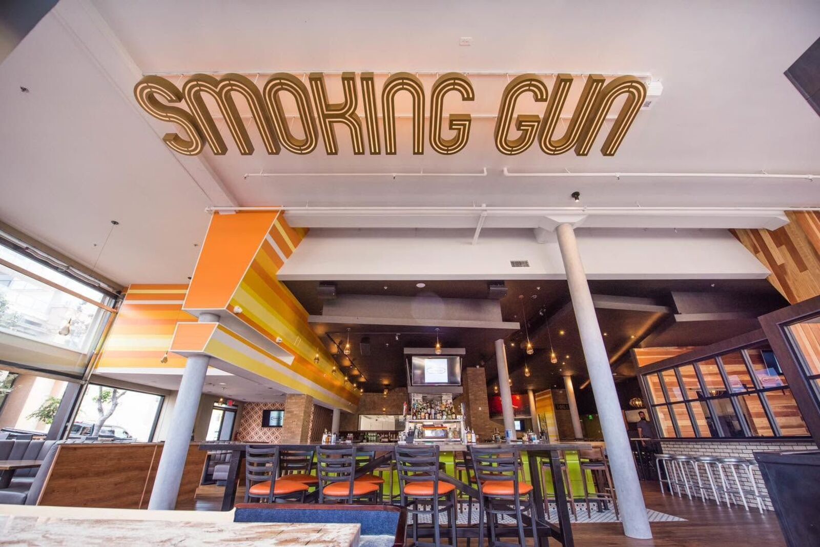 The main room at The Smoking Gun, with the bar and the Smoking Gun sign above it